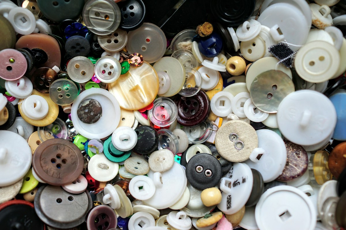 A loose collection of sewing buttons in pastel and neutral colours. Illustrative photograph for an original fictional story.